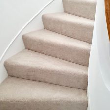 View up a spiral staircase fitted with a beige carpet by Victoria Carpets from their Tudor Twist range in cool ivory.