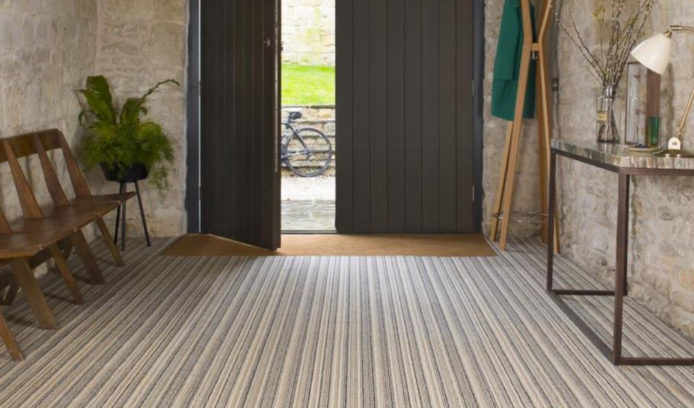 A striped carpet in a hallway with front door ajar, in neutral colours from the Pure Living range by Brintons.