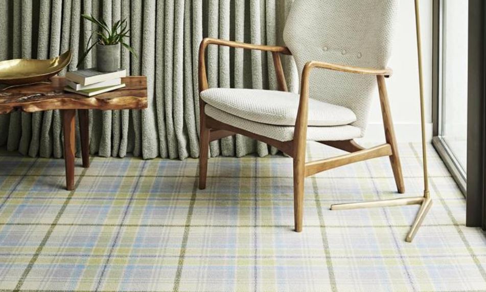 A chair and table in a living room with pale tartan carpet from the City Plaid range by Brintons.
