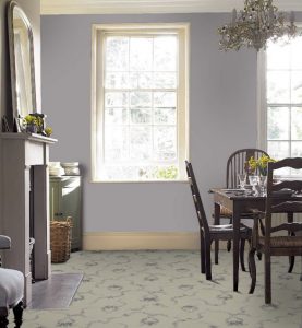 A dining room with dark furniture and lilac walls, with a floral carpet in pale yellow from Brintons.