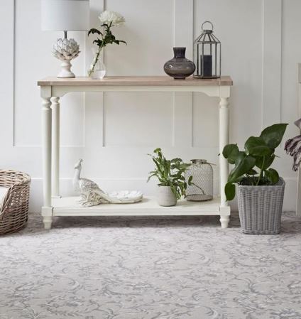 A sideboard with pale walls and patterned carpet from the Laura Ashley carpet range by Brintons.