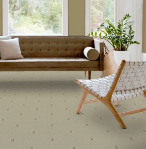A living room with sofa and armchair with a sand coloured carpet from the Marrakesh Naturals range by Brintons.