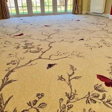 Woven Axminster carpet fitted in a living room, with a beige background and butterfly and leaf pattern