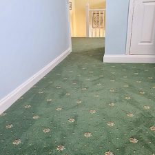 View of a bedroom fitted with a green patterned, heavy wear, woven Axminster carpet.