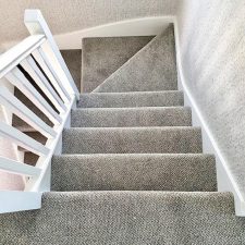 View down a flight of stairs fitted with a mid grey polypropylene carpet.