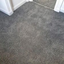 View of a landing fitted with a dark grey heavy domestic carpet.