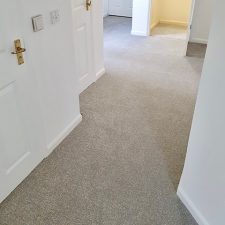View of a hallway fitted with a beige Polypropylene twist pile carpet