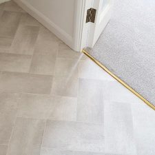 Closeup view of a hall fitted with grey vinyl and a threshold with grey polypropylene carpet.