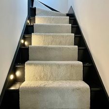 View up a flight of stairs fitted with a neutral carpet runner made from Polypropylene saxony with a long soft luxurious pile.