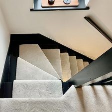 View down a flight of stairs fitted with a neutral carpet runner made from Polypropylene saxony with a long soft luxurious pile.