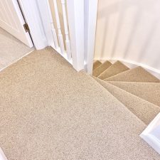 View down a flight of stairs fitted with a beige wool loop 2 ply yarn, moth resistant carpet