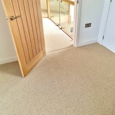 View from a bedroom onto a landing fitted with a beige wool loop, 2 play carpet in a cottonwood shade