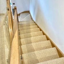 View down a flight of stairs fitted with a beige wool loop, 2 play carpet in a cottonwood shade