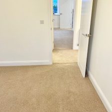 View of a bedroom fitted with a beige 80% wool berber twist pile heavy domestic carpet