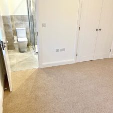 View of a bedroom fitted with a beige 80% wool berber twist pile heavy domestic carpet