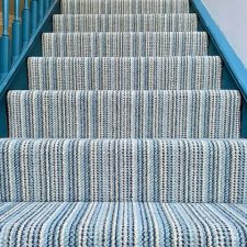 View up a staircase with striped high and low level wool loop moth resistant carpet.
