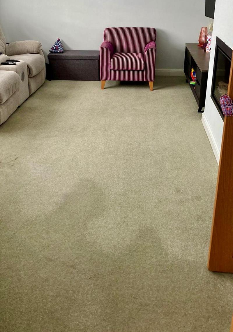 A beige lounge carpet with discoloured patches caused by carpet pile reversal.