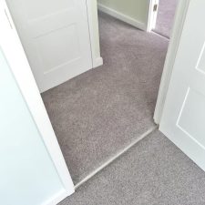 View into a hallway fitted with a grey wool/synthetic twist carpet.
