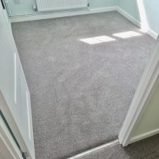 View into a bedroom with grey twist carpet.