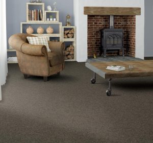 A living room with wood burner, shelf unit, brown furniture and deep brown wool carpet from the Crofter Loop range by Penthouse Carpets.