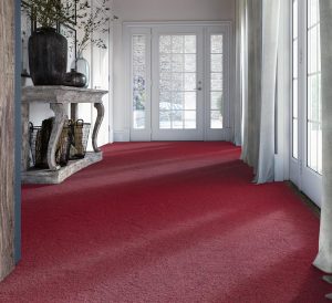 Hallway with display table and views onto a courtyard with deep cherry wool carpet.