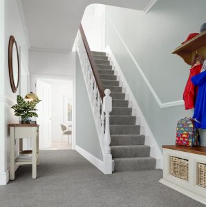 Downstairs hallway and stairs with grey walls, white painted woodwork and grey wool carpet.
