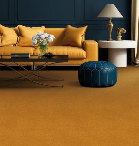 Living room with yellow sofa, dark grey walls and deep mustard wool carpet from the Stateside range by Penthouse Carpets.