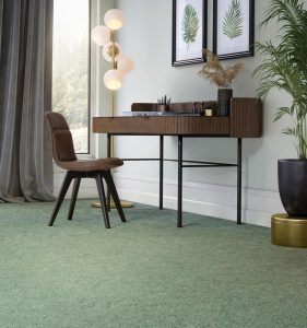Living room with dark brown wooden desk and chair, with mid green carpet from the Vermont range by Penthouse Carpets.