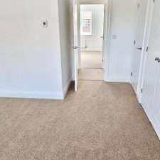 View of a bedroom floor fitted with a beige wool/synthetic quality twist carpet.
