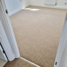 View into a bedroom fitted with a beige wool/synthetic quality twist carpet.