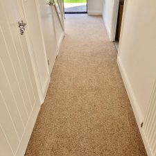 View of a hallway fitted with a beige twist carpet.