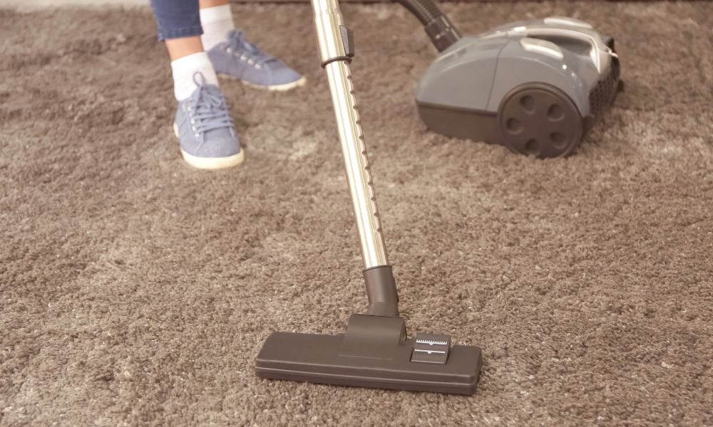 Closeup of a hoover cleaning a carpet to remove dust mite particles