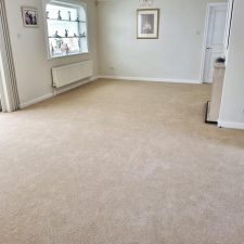 View of a living room fitted with an 80% wool, 20% nylon woven Wilton construction carpet in a bungalow on the Willowhayne Estate in East Preston.