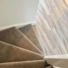 View down a flight of stairs fitted with a brown polypropylene twist carpet.