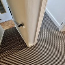 View of a landing and stairs fitted with a two-tone striped heavy domestic wool carpet.