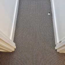 View of a hallway fitted with a two-tone striped British wool carpet.