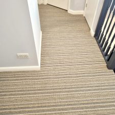 View of an upper landing fitted with a striped beige/brown high and low level wool loop, moth resistant carpet.