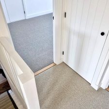 View out of a bedroom fitted with neutral beige undyed natural wool loop carpet.