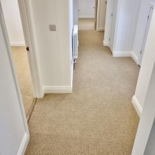 View of a hallway fitted with beige wool loop, moth proof carpet in a renovated house in Itchenor.