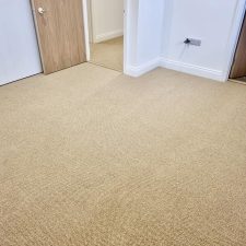 View of a living room fitted with beige wool loop, moth proof carpet in a renovated house in Itchenor.