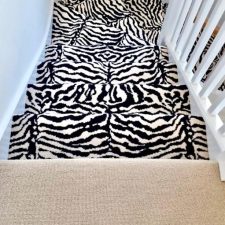 View down a flight of stairs fitted with a zebra design axminster carpet