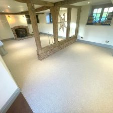 View of a large living room in a refurbished cottage fitted with a beige wool loop natural effect carpet.