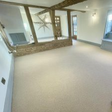 View of a large living room in a refurbished cottage fitted with a beige wool loop natural effect carpet.
