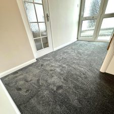 A charcoal coloured nylon saxony carpet fitted to a hall with front door and internal doors shown with frosted glass.