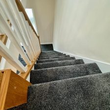 View up a flight of stairs fitted with a high quality charcoal coloured saxony carpet.