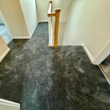 View of an upstairs landing fitted with a charcoal coloured nylon saxony carpet.