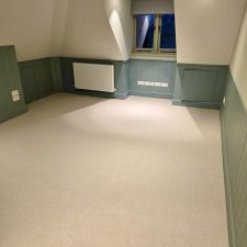 Beige carpet fitted in a loft room with sloped ceilings.